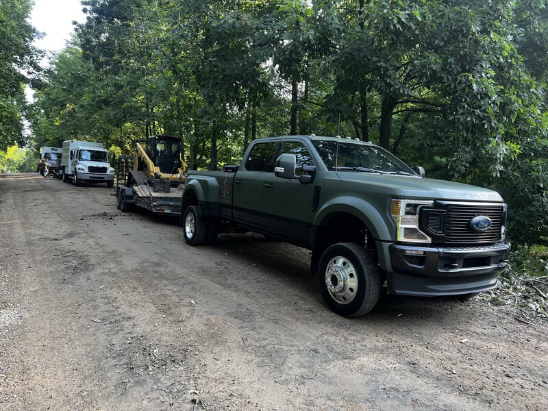 Trees and Co. truck with trailer en route to a grinding job